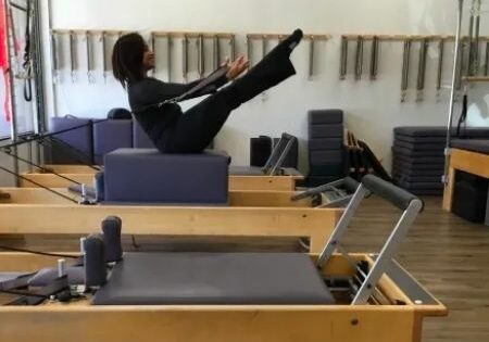woman on pilates reformer machine